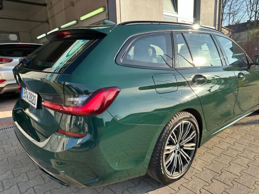 Glänzende Heck- und Seitenpartie eines grünen BMW im Sonnenlicht