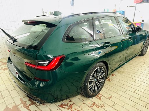 Grüner BMW Touring mit Lackreflexionen in der Werkstatt