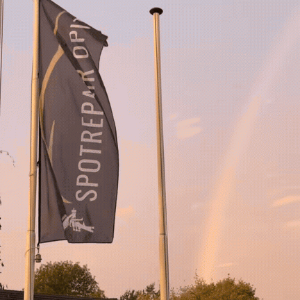 Fahne von Spotrepair Opitz vor dem Abendhimmel mit Regenbogen