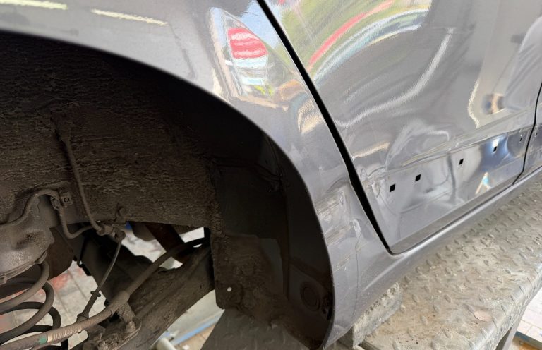 Fahrzeugschäden instand setzen Reparaturarbeiten an einer beschädigten Fahrzeugseite
