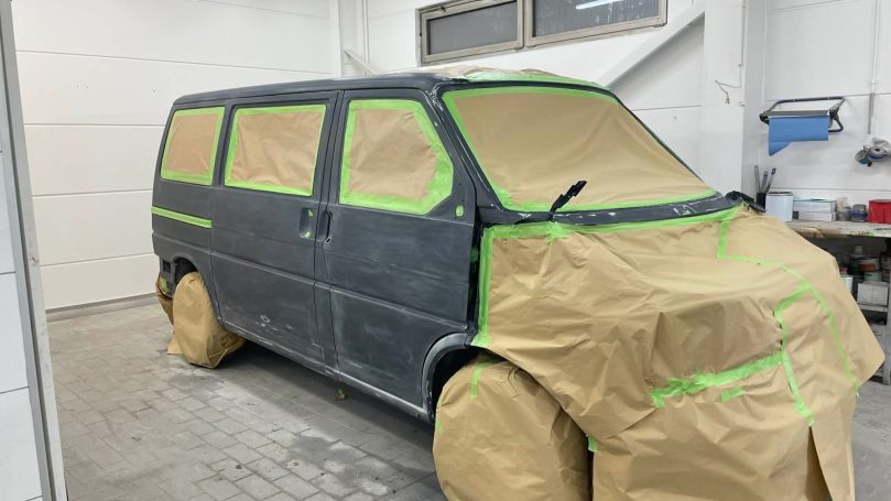 Vorbereiteter VW T4 mit abgeklebten Scheiben und geschütztem Vorderwagen
