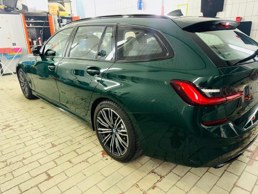Seitenansicht eines grünen BMW Touring in der Werkstatt