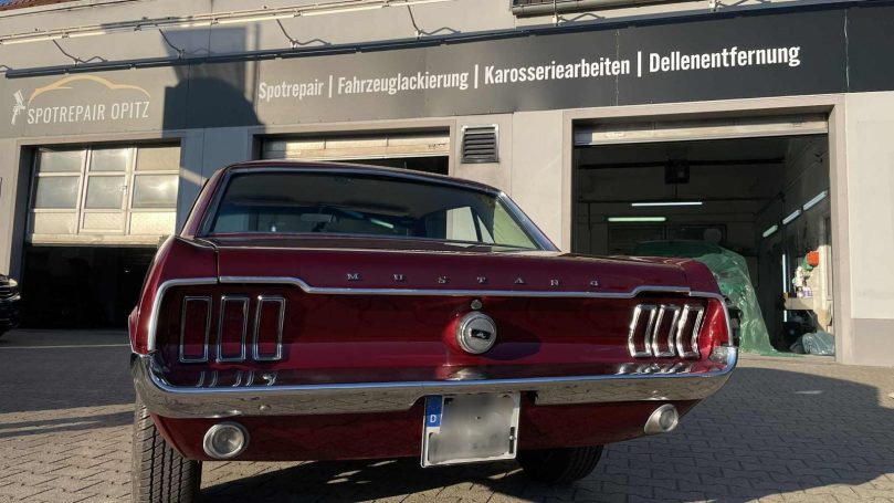 Zusammengebautes Heck des roten Ford Mustang mit Leuchten und Chromstoßstange
