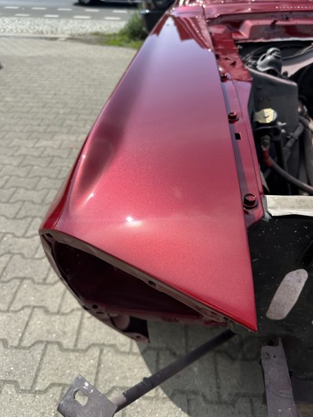 Nahaufnahme des rot lackierten Mustang-Kotflügels im Sonnenlicht