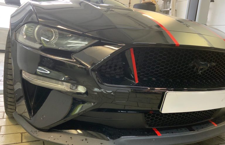 Scheinwerferaufbereitung Scheinwerfer und Frontpartie eines Ford Mustang in der Werkstatt